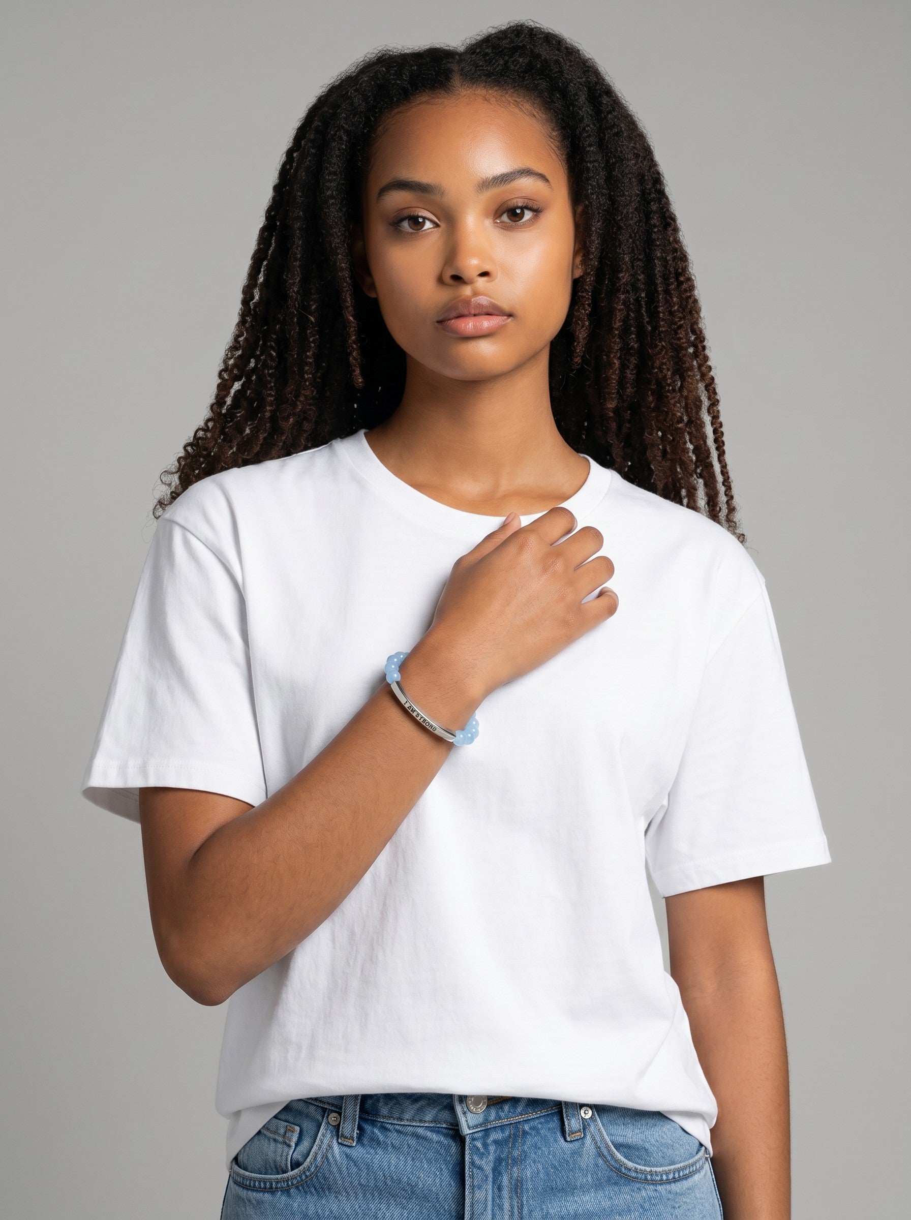 Color's Wholesale beaded charm bracelet with a silver bar pendant worn by a woman in a white t-shirt