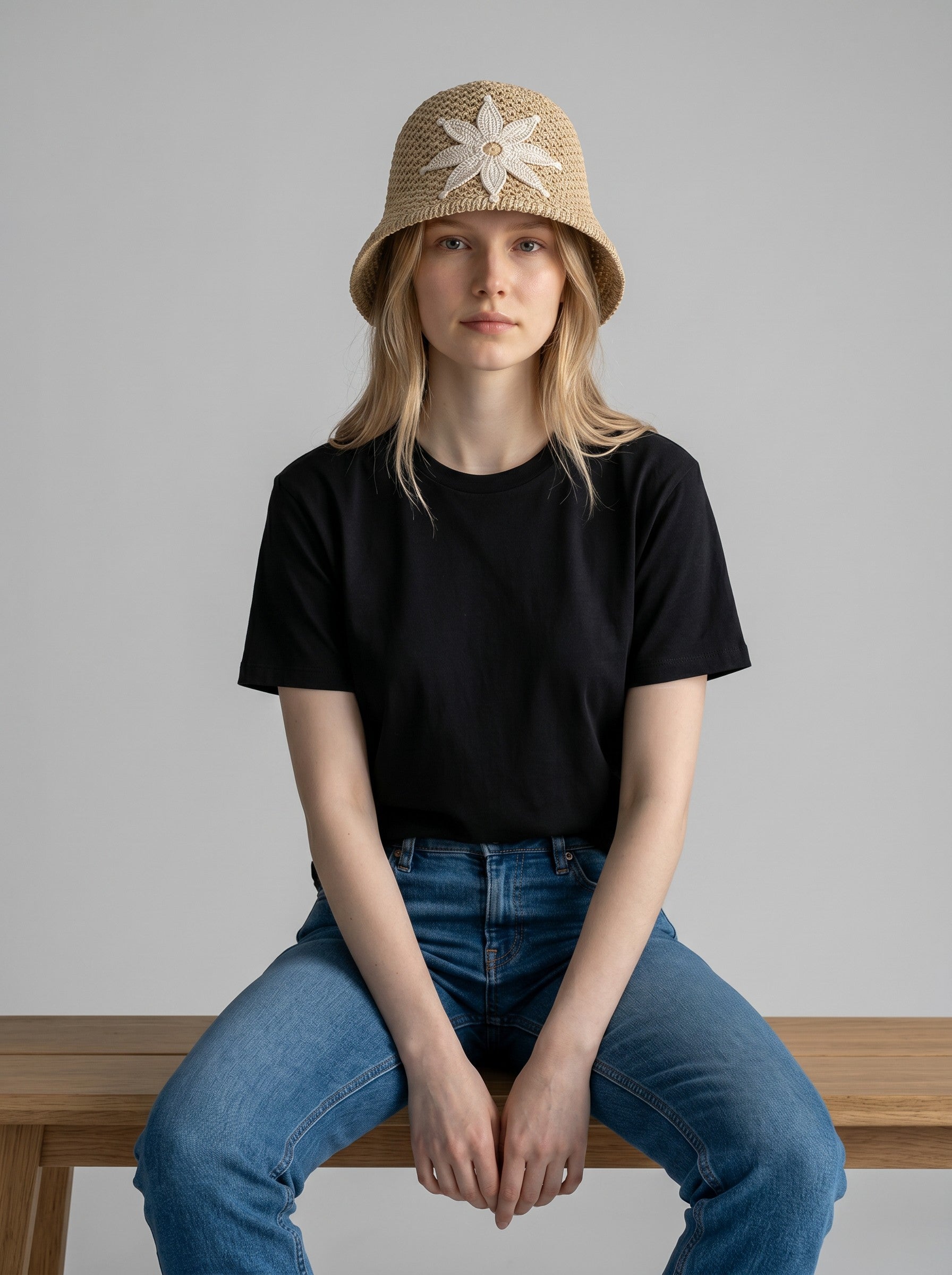 Color's Wholesale beige crocheted bucket hat with white floral appliqué detail. Made from thick cotton yarn.