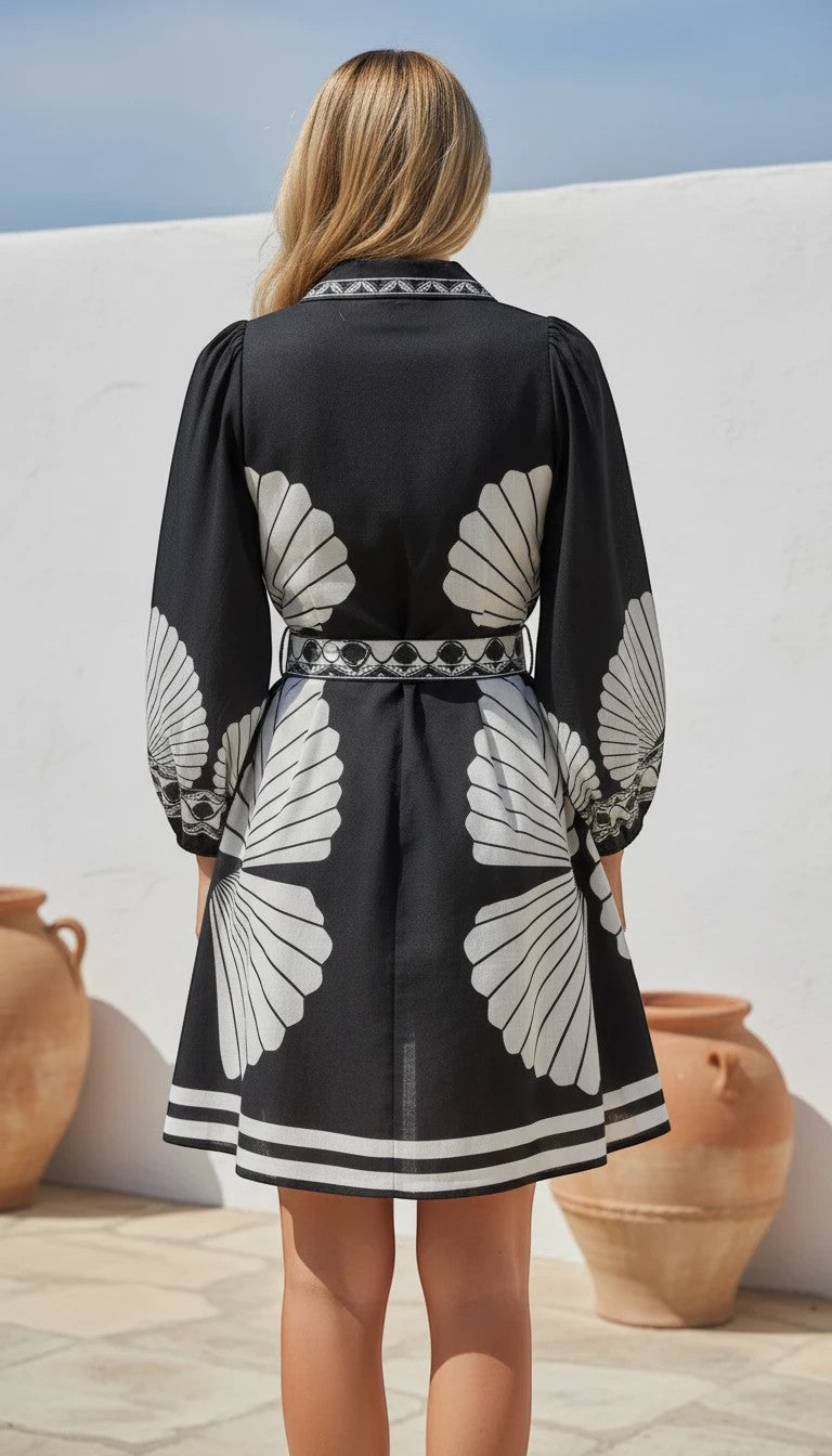 Color's Wholesale black linen-blend dress with white shell print, puff sleeves, and belted waist. Fits UK 10-16.