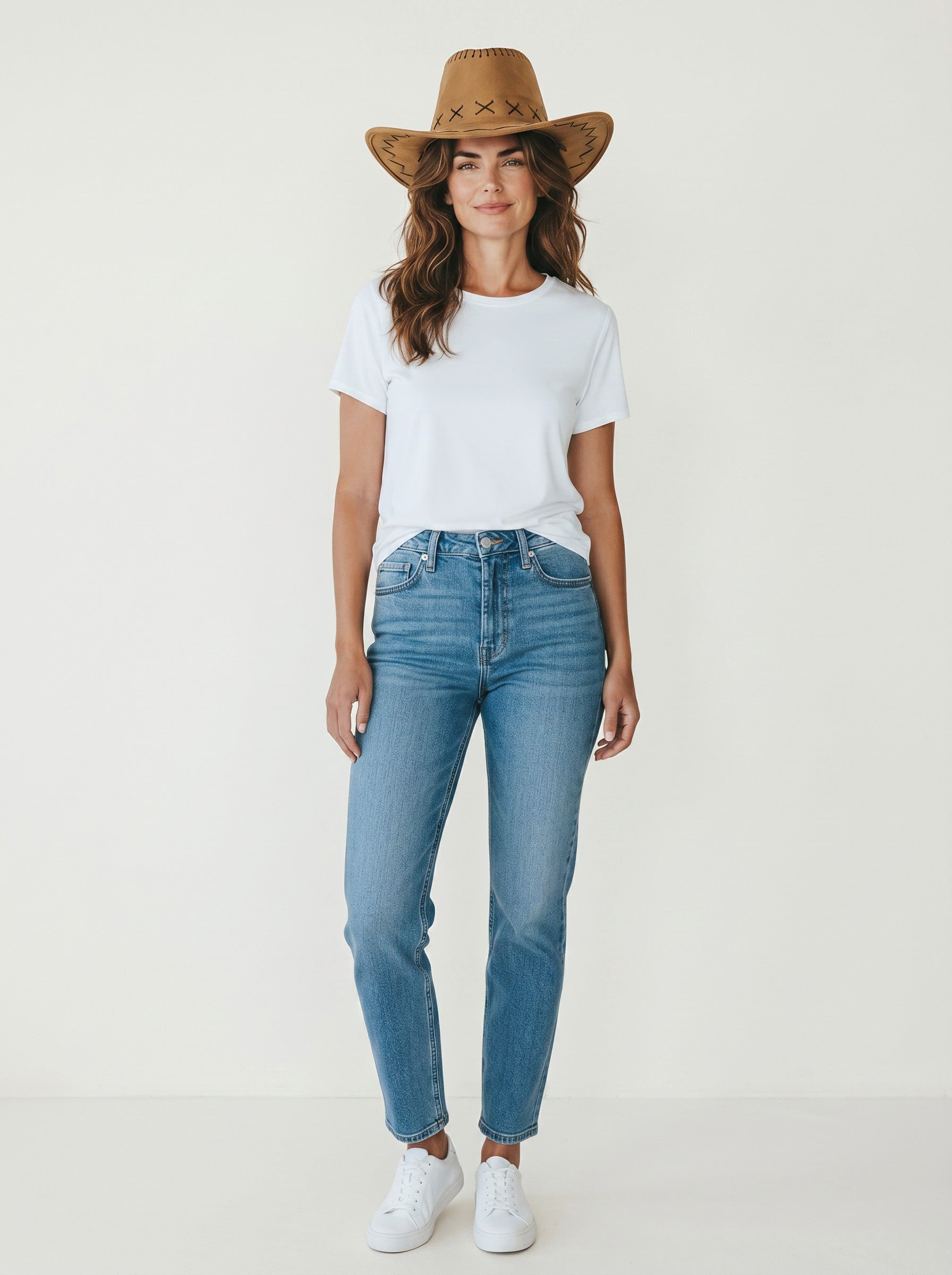 Woman wearing a brown faux leather Color's Wholesale cowboy hat with stitched detailing and a white t-shirt