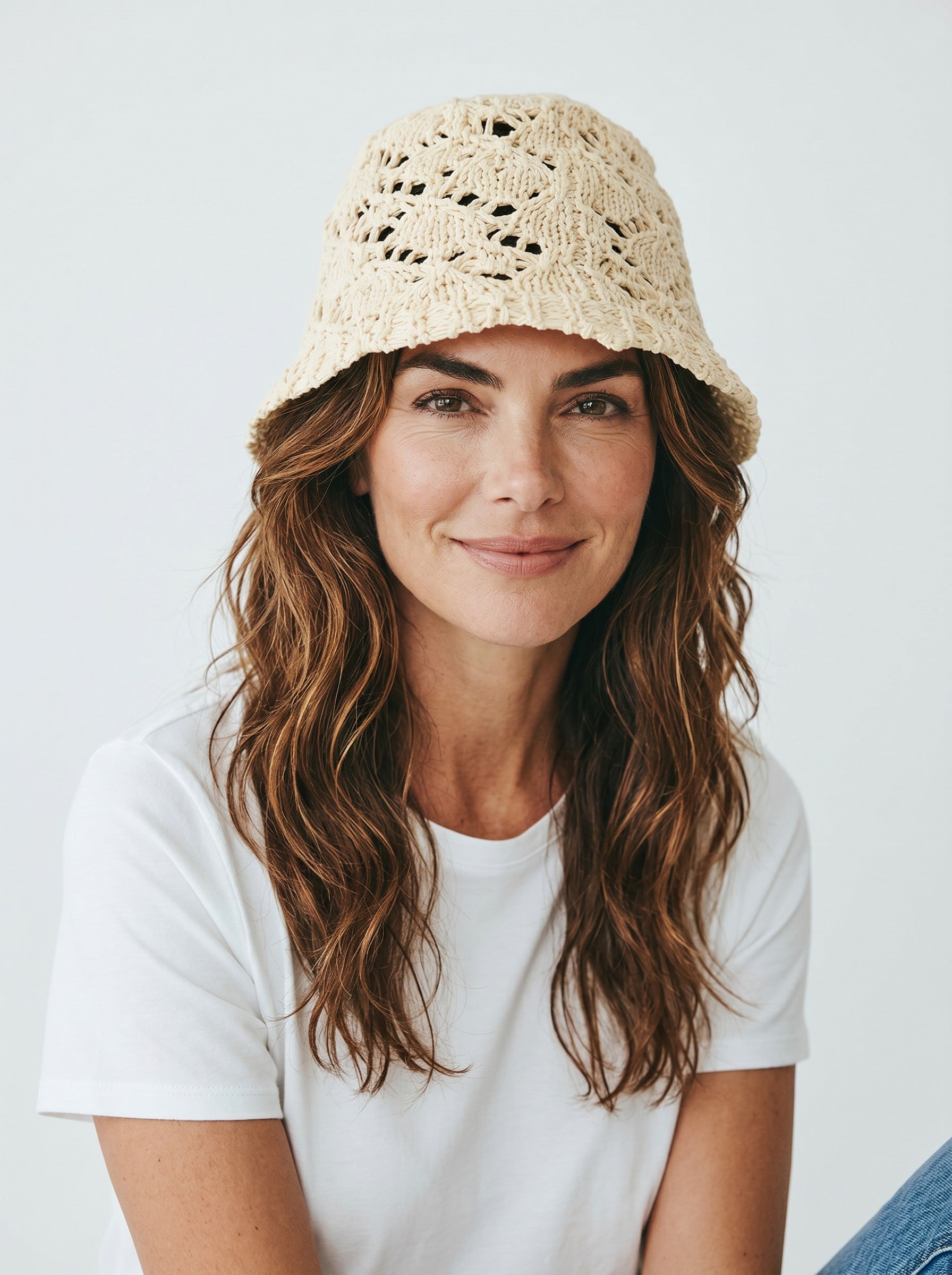 Color's Wholesale cream-colored crocheted cotton bucket hat with open knit pattern and wide brim.