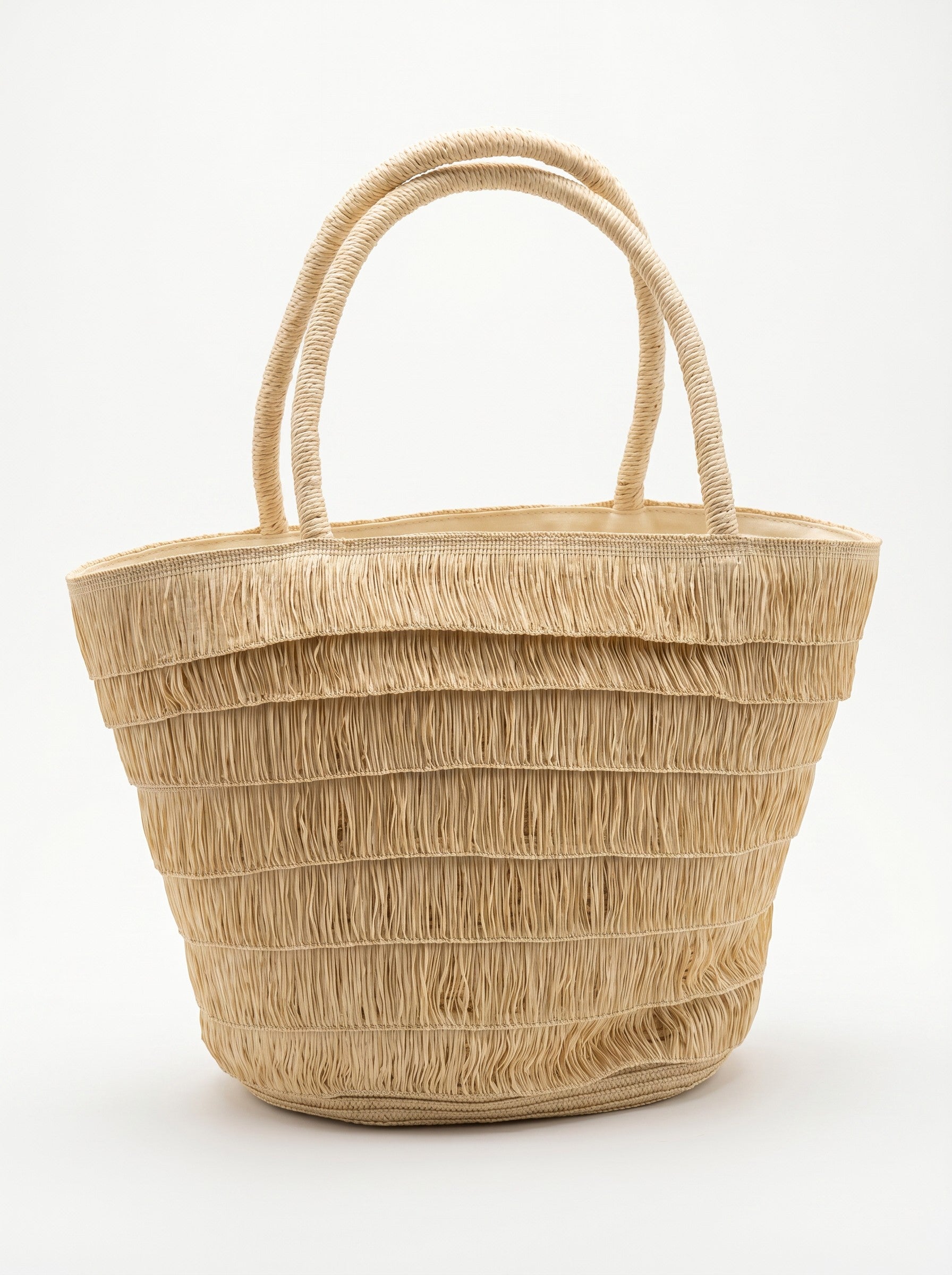 Color's Wholesale Eloise straw tote bag with fringe detail and double handles. Natural straw material, perfect for summer beachwear.