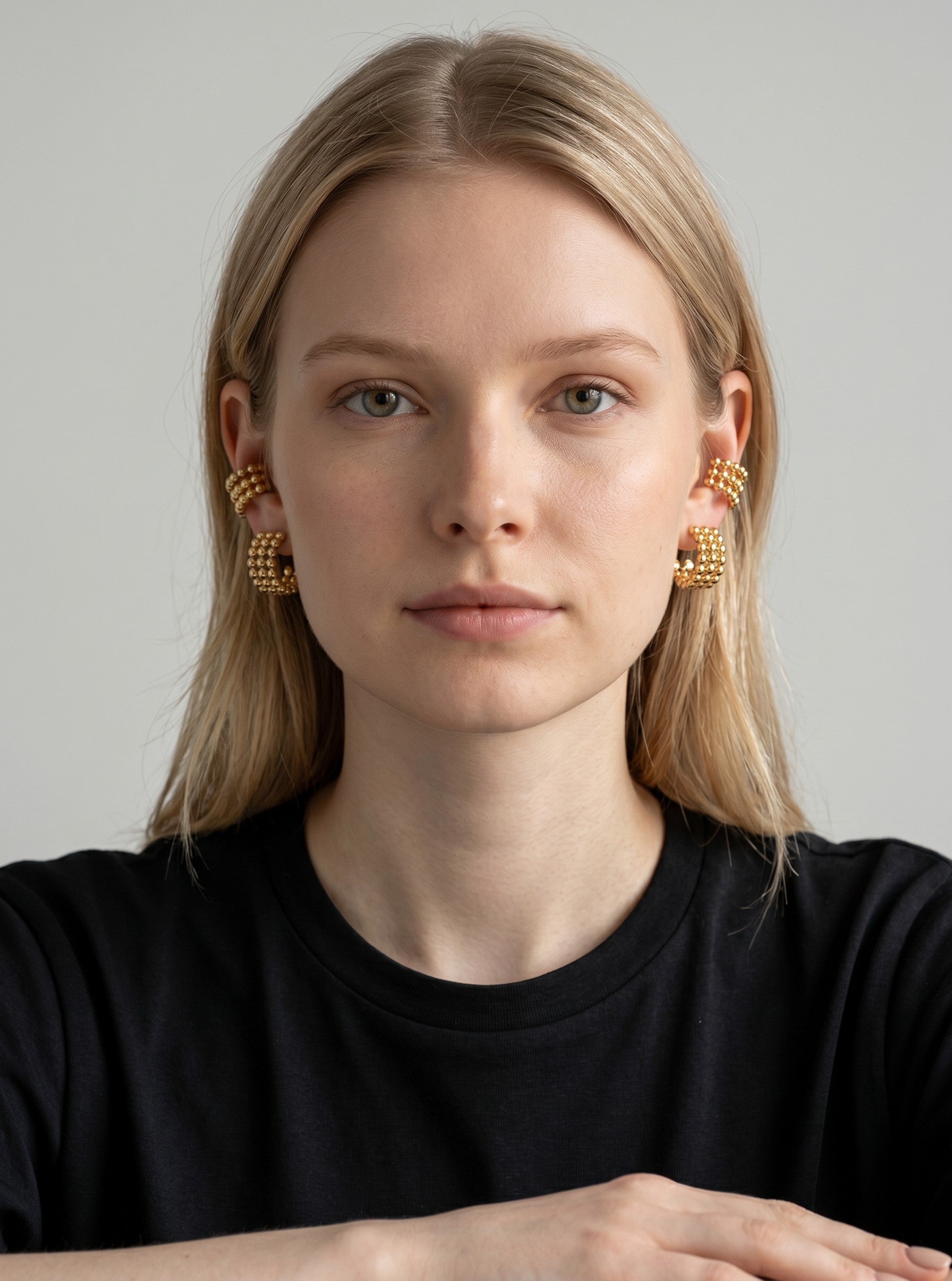 Model wearing Color's Wholesale gold-tone beaded hoop earrings and matching ear cuffs on both ears.