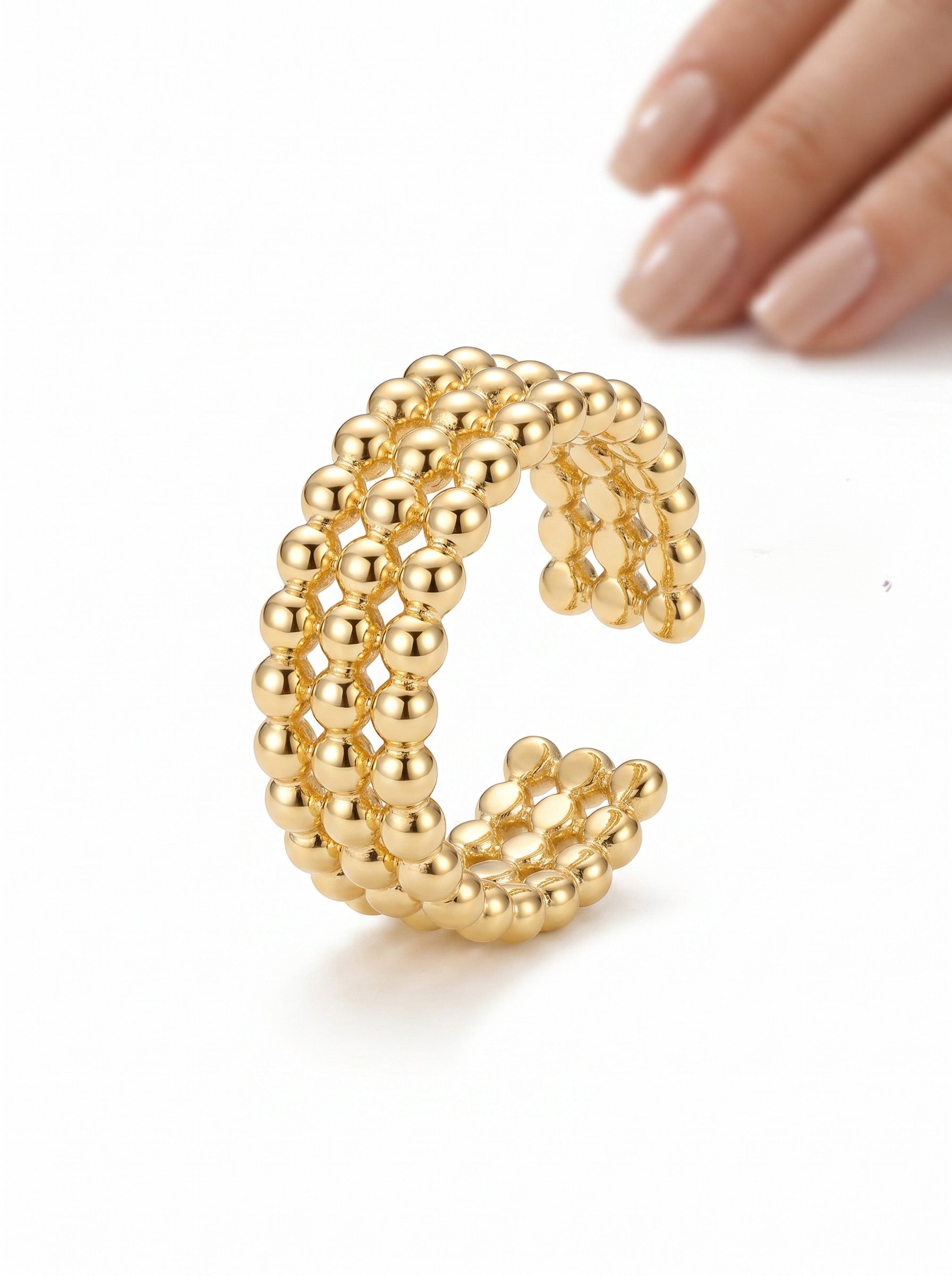 Color's Wholesale gold-tone triple-row beaded open ring with a polished finish worn on a finger