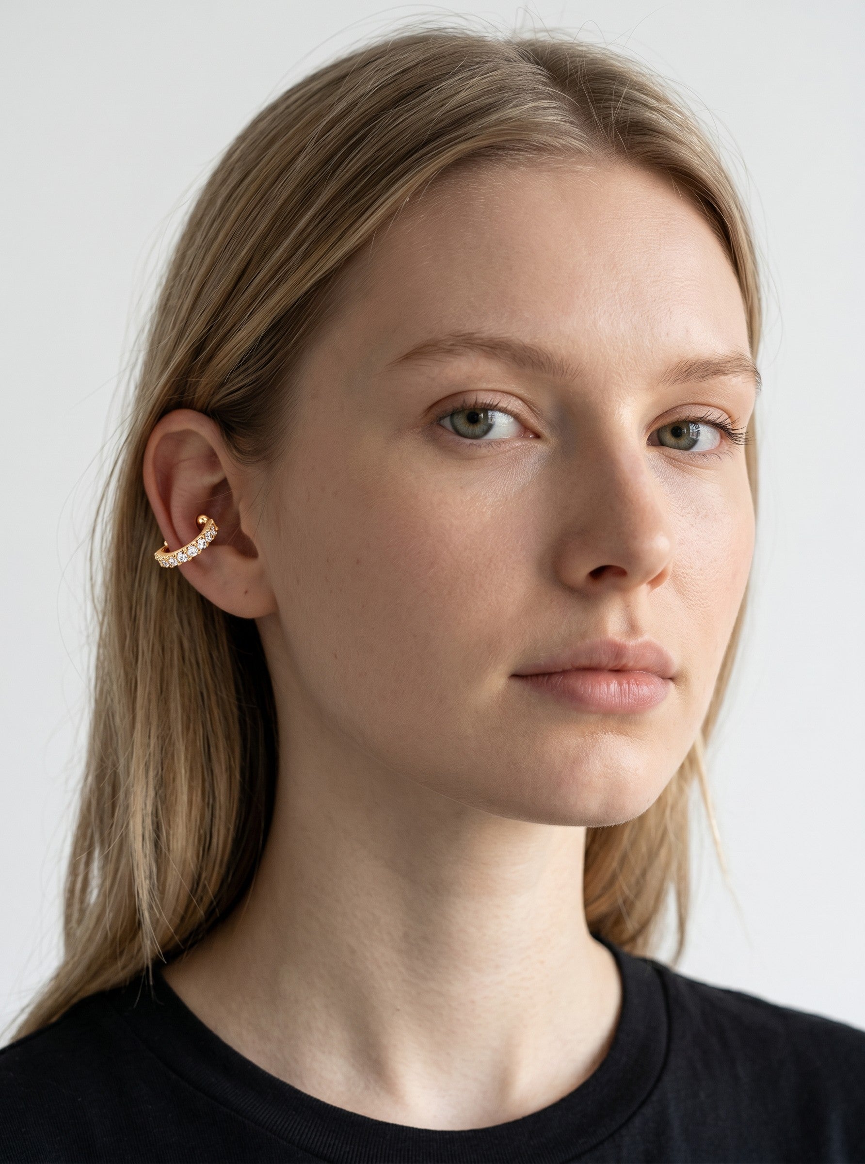 Model wearing a Color's Wholesale gold-tone ear cuff featuring a row of sparkling clear cubic zirconia stones