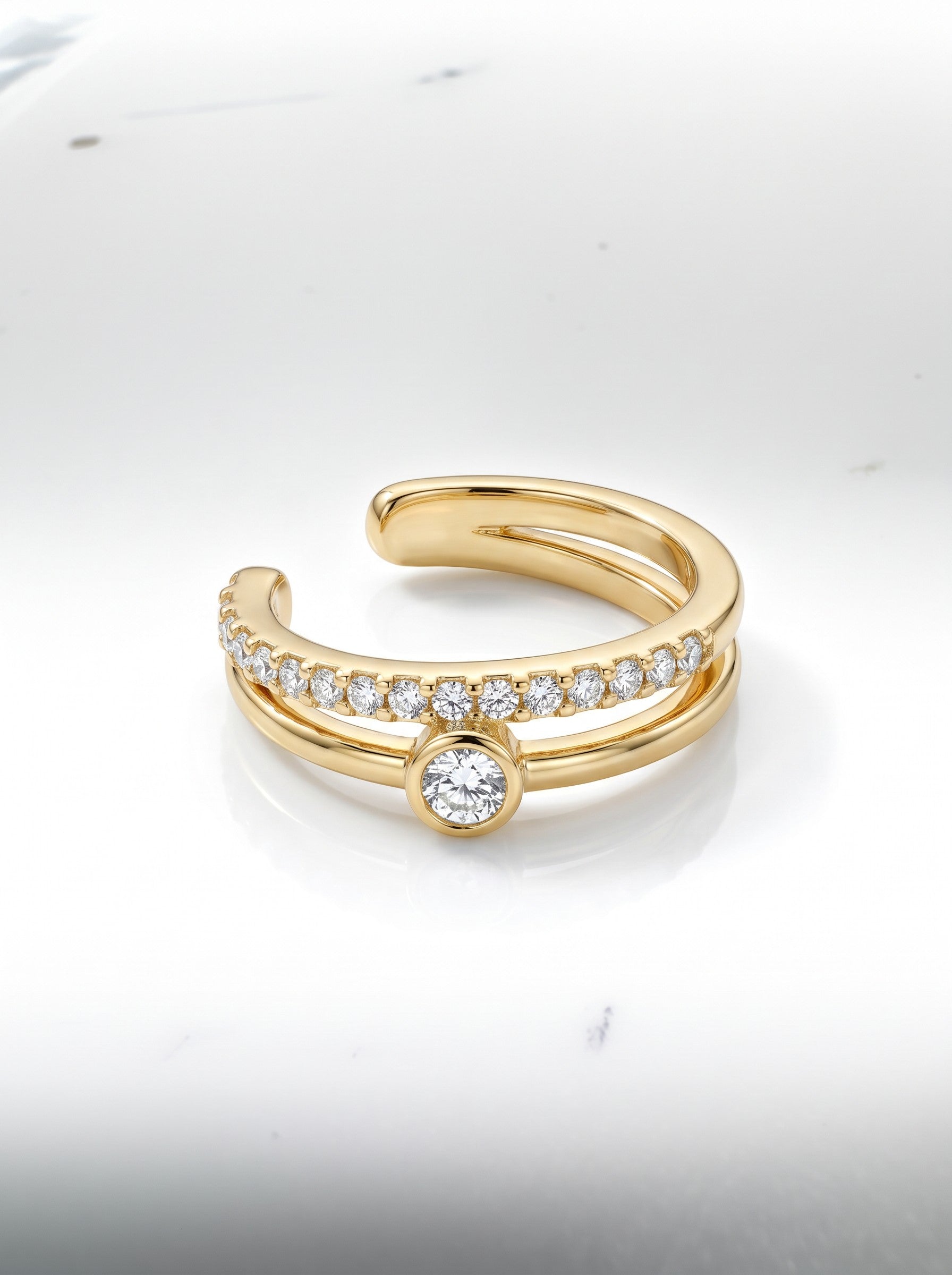 Color's Wholesale gold double-band ear cuff featuring a row of pavé diamonds and a central bezel-set solitaire stone.