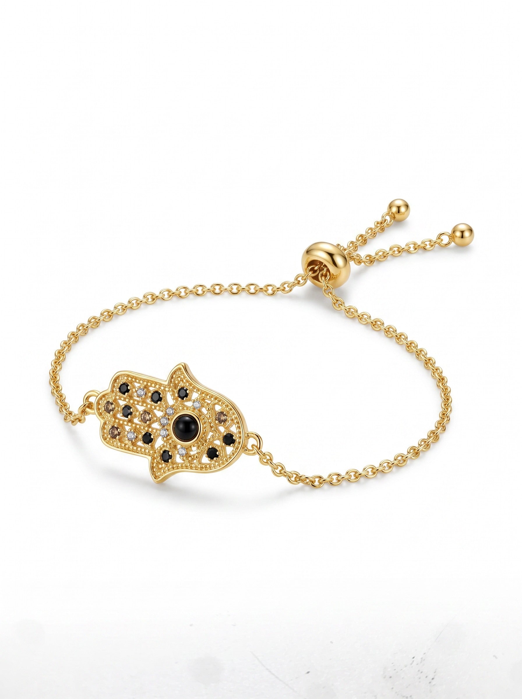 Color's Wholesale gold hamsa hand charm bracelet with black and clear crystals on an adjustable chain