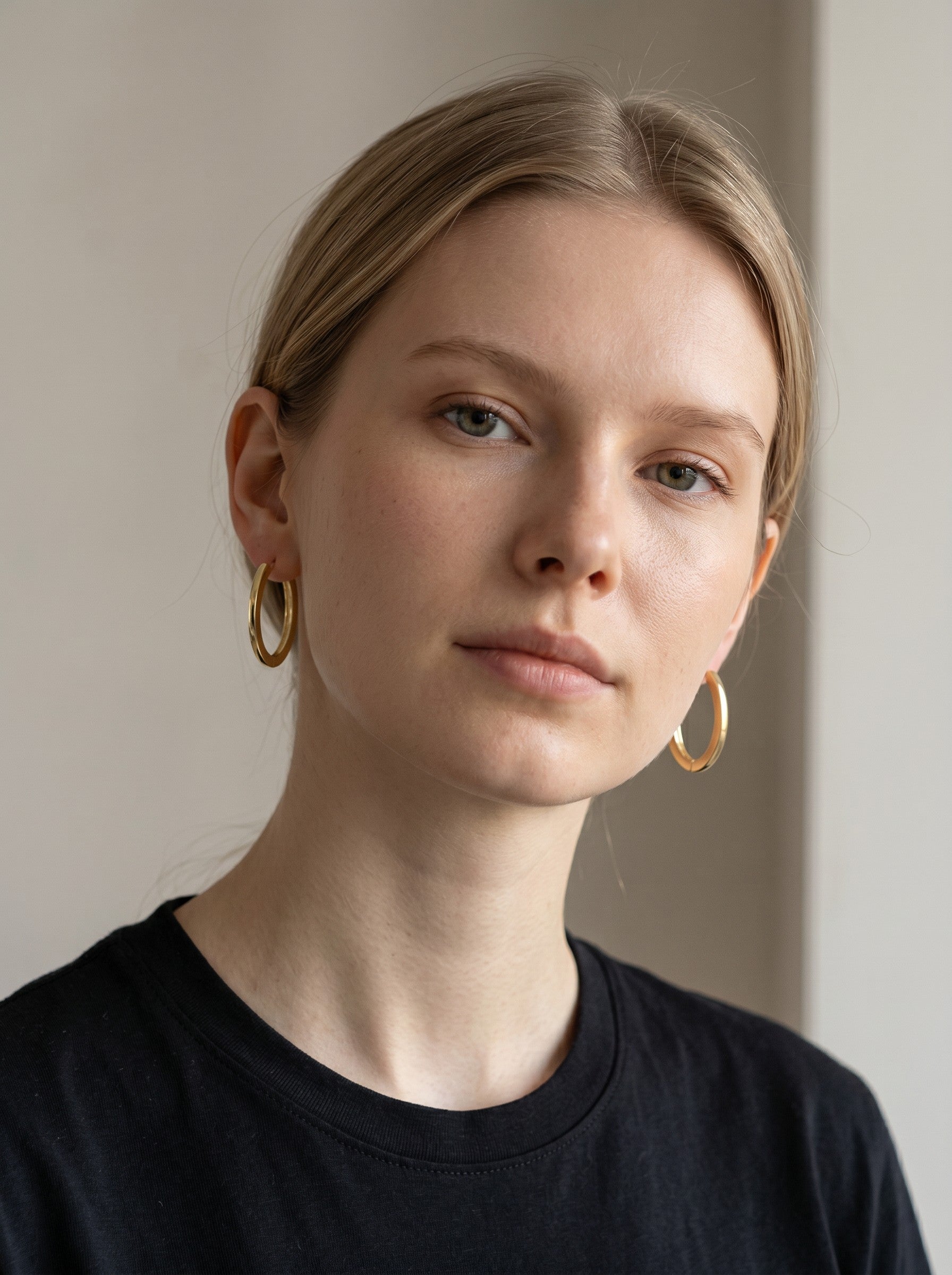 A model wearing classic gold hoop earrings from Color's Wholesale, featuring a polished finish and minimalist design.