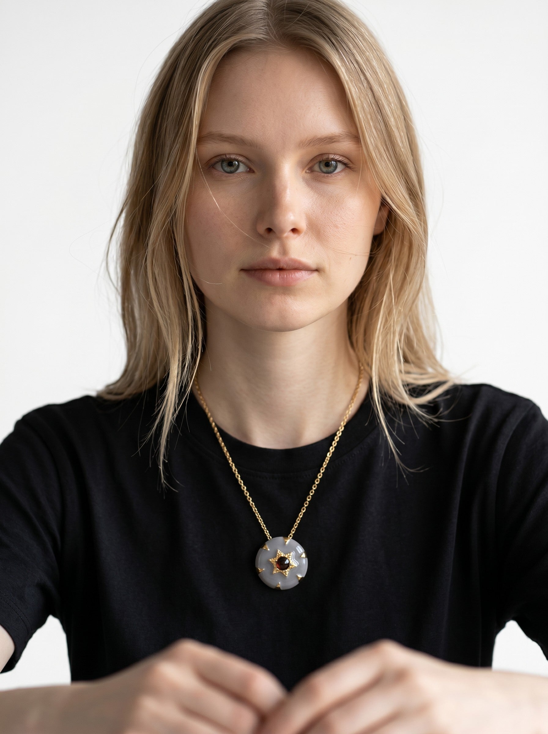Color's Wholesale gold chain necklace featuring a round grey stone pendant with a central star-shaped garnet accent