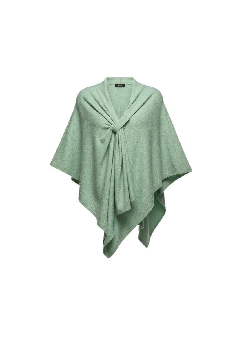 Color's Wholesale light green knit poncho with a tie detail, worn over a black top and blue jeans.