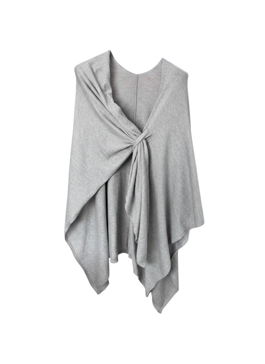 Color's Wholesale light grey knit poncho with a twisted knot detail and coral lining.