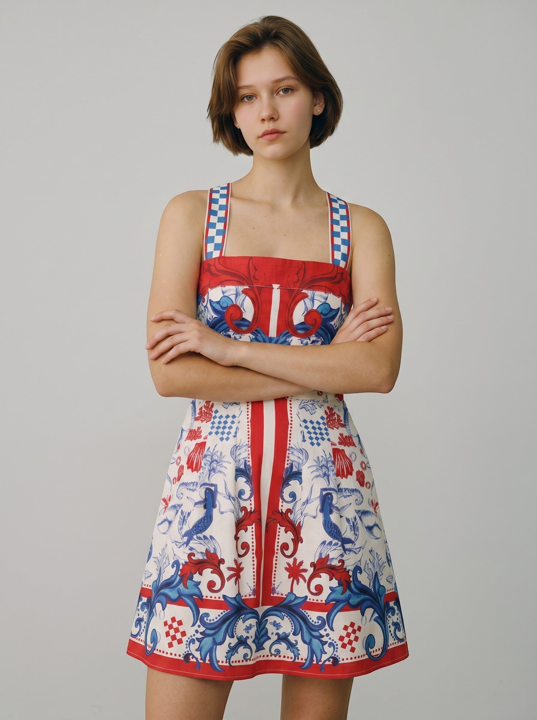 Color's Wholesale white linen-blend mini dress with red and blue ornate print, square neckline, and checkered straps. Fits UK 10-16.