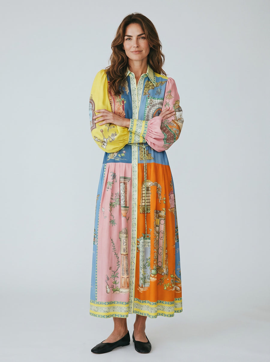 Color's Wholesale maxi shirt dress with a colorful patchwork print, balloon sleeves, and a belted waist. Made of 65% linen, 35% polyester.