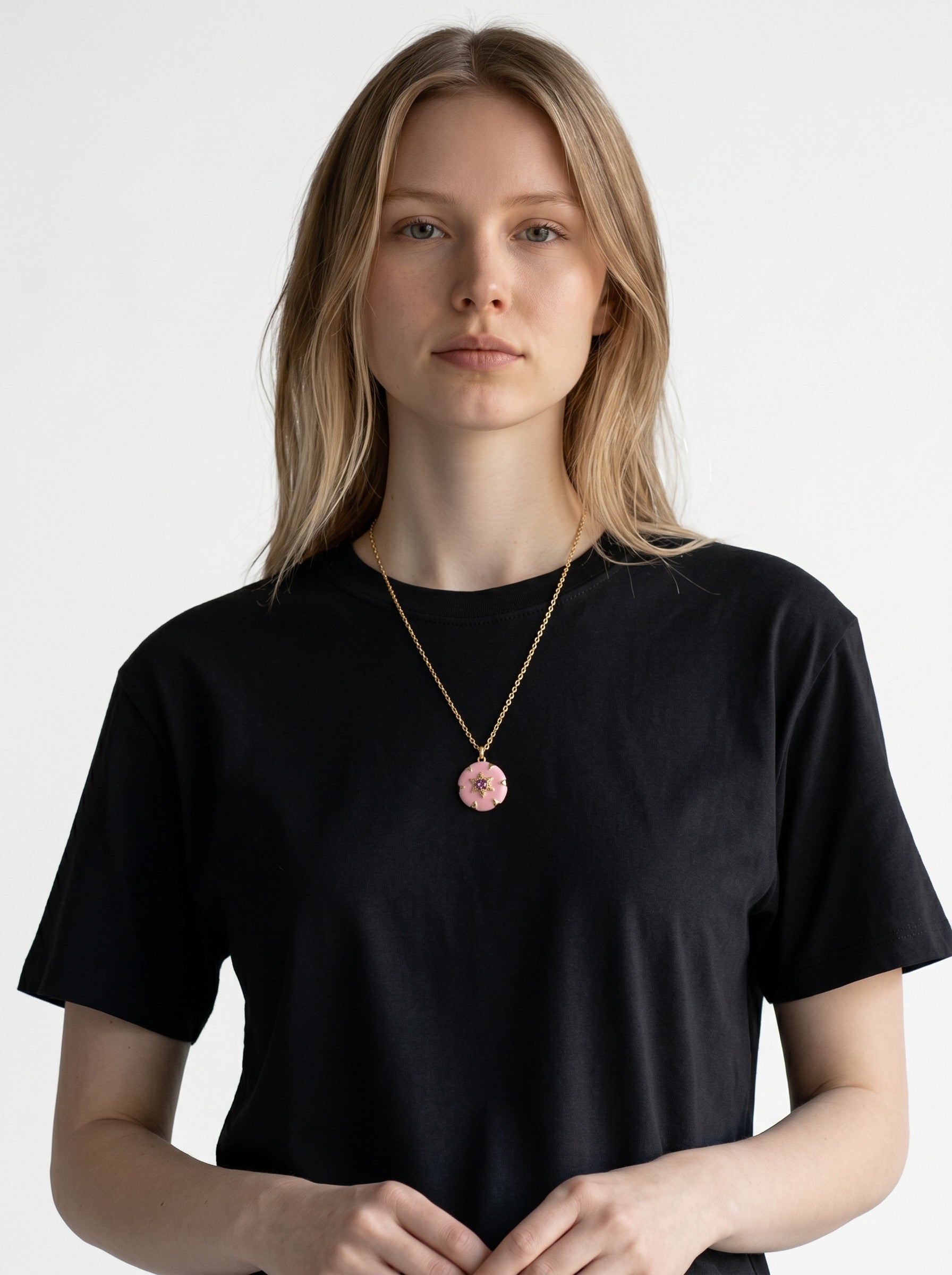 Model wearing a Color's Wholesale gold chain necklace with a pink flower pendant featuring a central crystal accent.