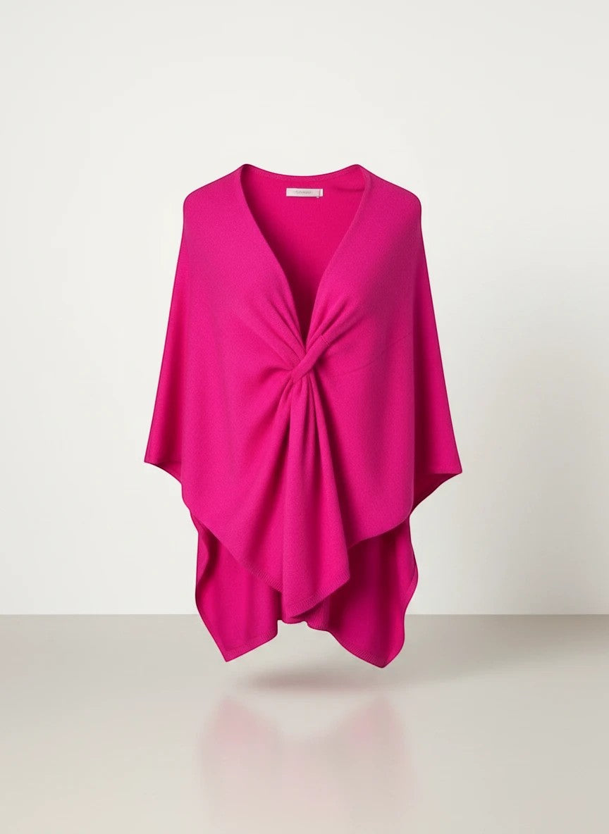 Color's Wholesale bright pink knit poncho with a twisted knot detail at the V-neck.