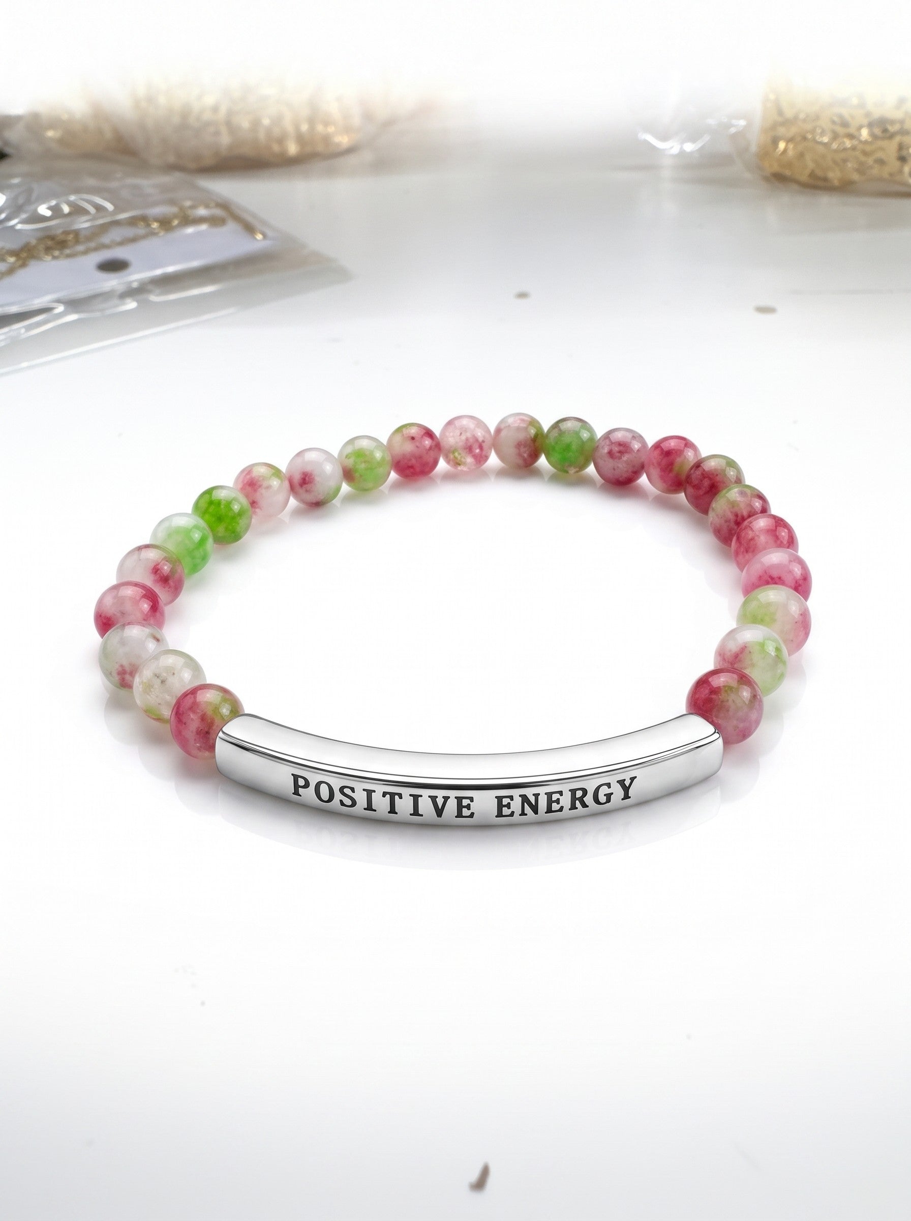 Color's Wholesale beaded bracelet with pink and green marbled beads and a silver bar engraved with Positive Energy