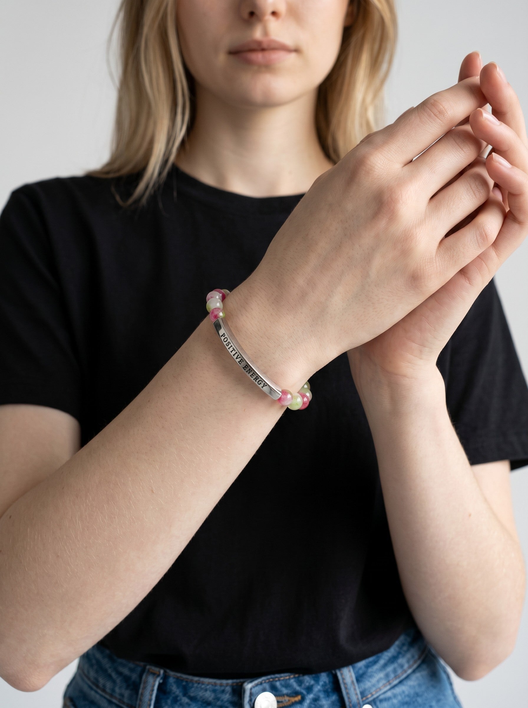 Color's Wholesale beaded bracelet with a silver bar charm engraved with Positive Energy worn on a woman's wrist