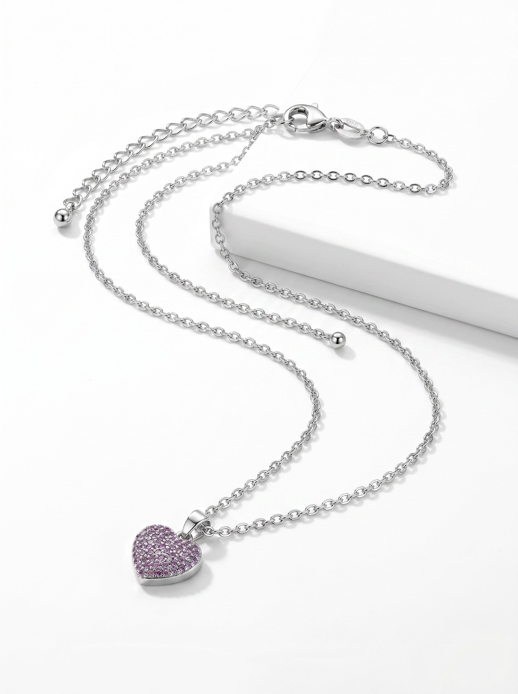 Color's Wholesale silver chain necklace featuring a small heart pendant encrusted with sparkling purple crystals