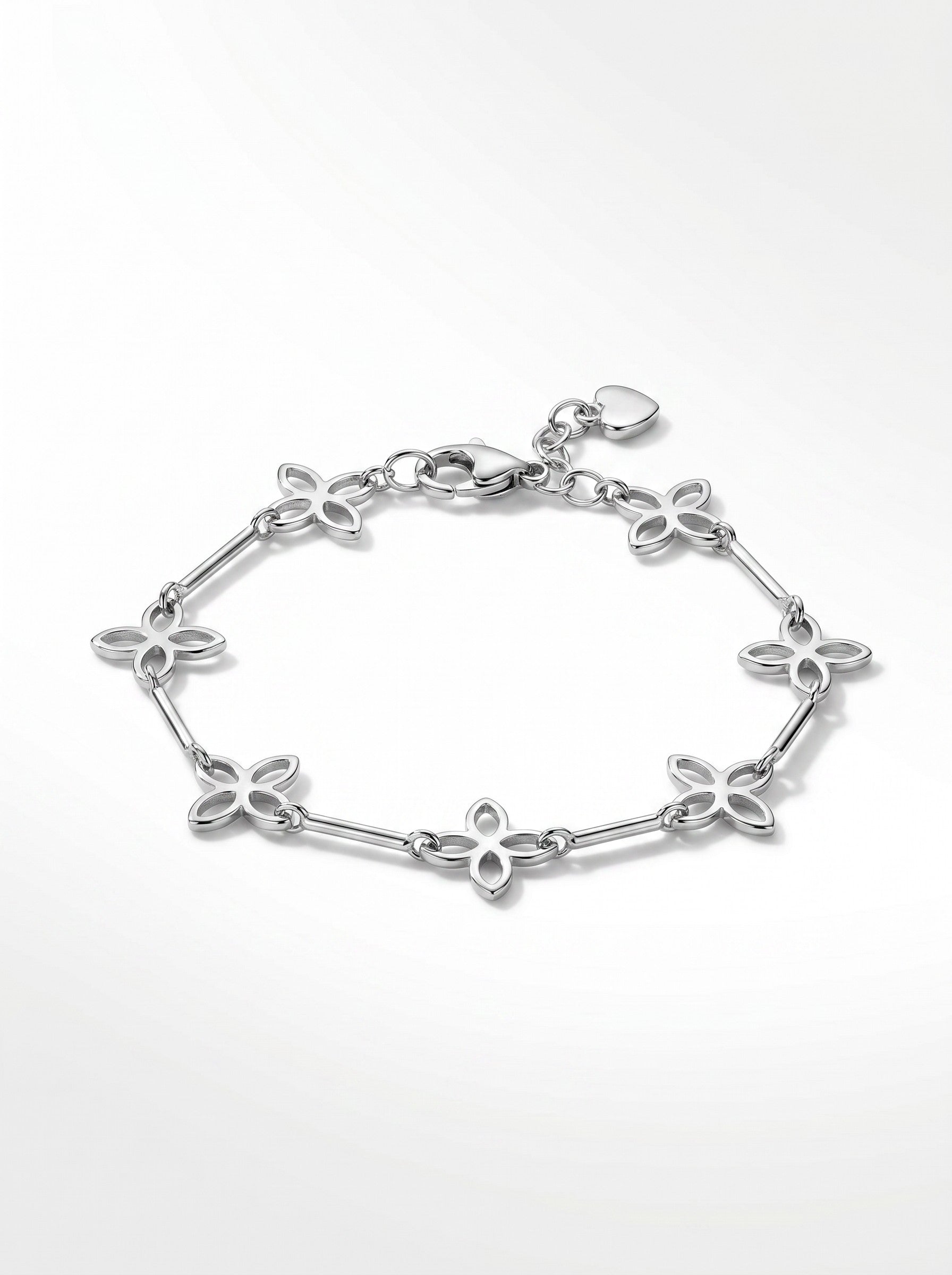 Color's Wholesale silver-tone charm bracelet featuring delicate openwork flower links and a small heart pendant.