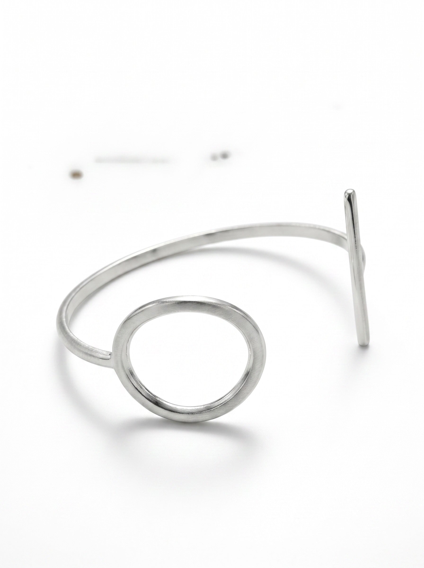 Color's Wholesale silver tone open cuff bracelet featuring a minimalist circular design on a white background
