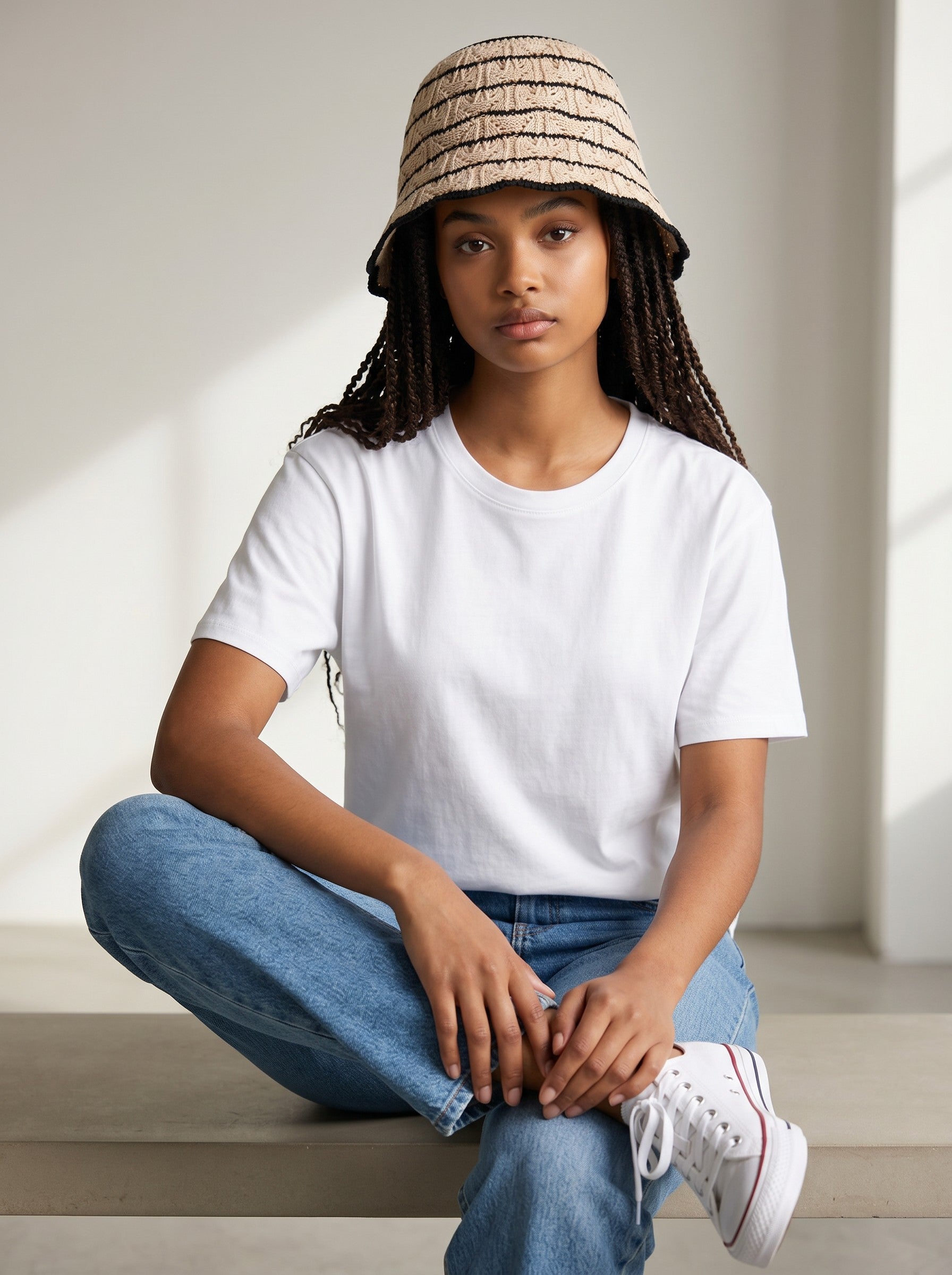 Color's Wholesale beige and black striped crochet bucket hat with a black trim.
