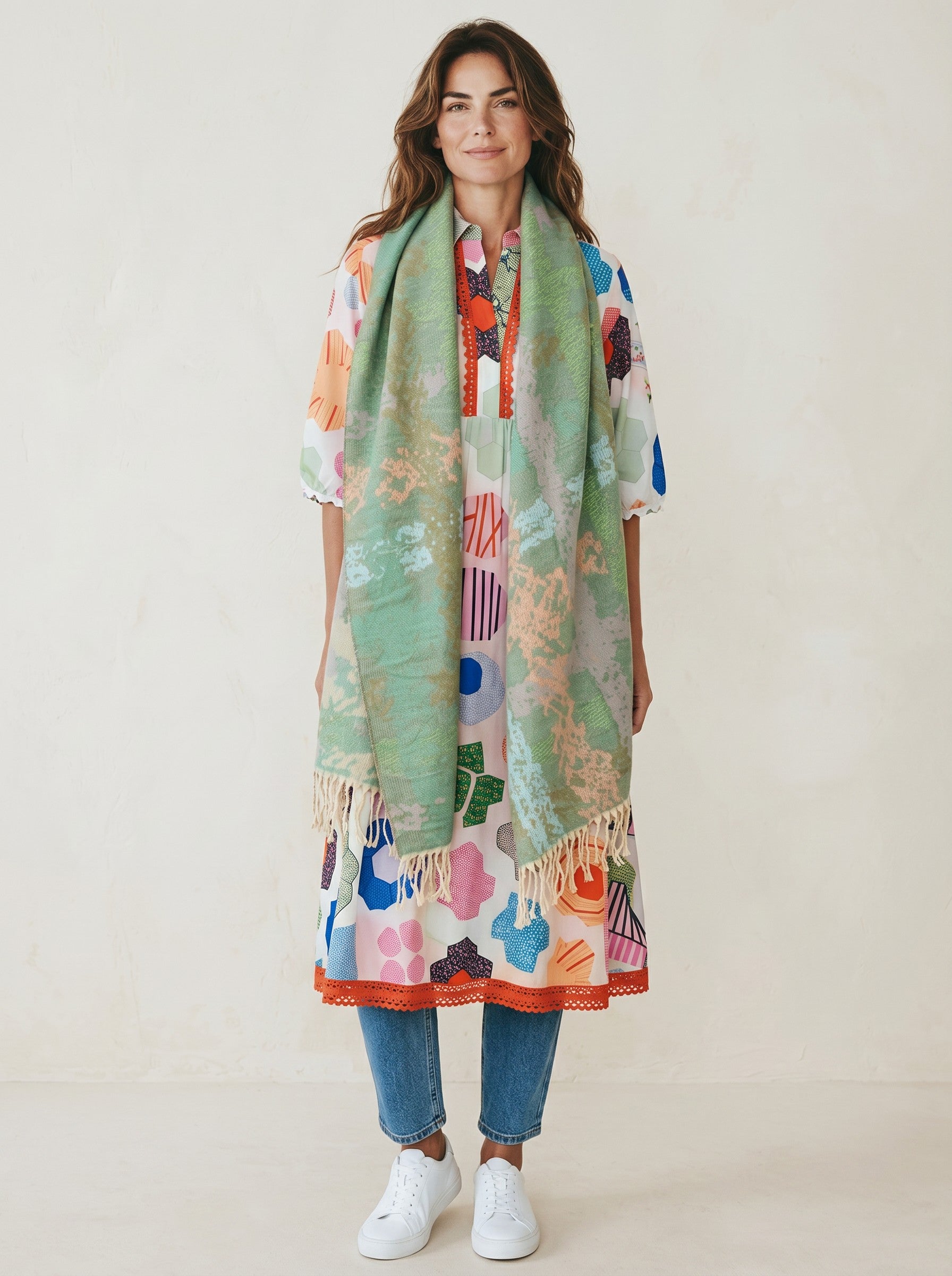 Model wearing a Color's Wholesale viscose dress with a colorful geometric print and a soft green textured scarf.